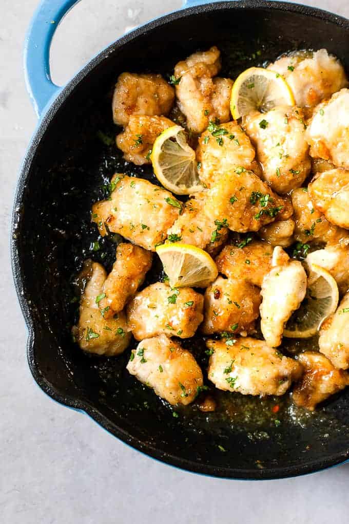 Chinese lemon chicken with honey and lemon garlic sauce in a pan.