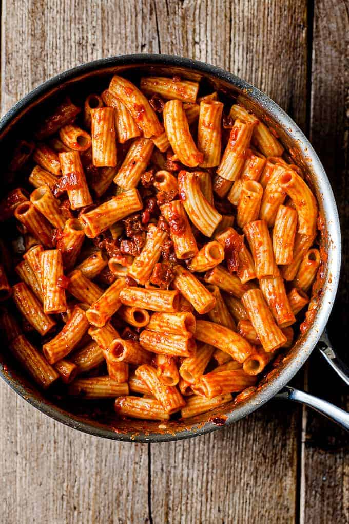 Chorizo pasta in a pan on a wooden table.