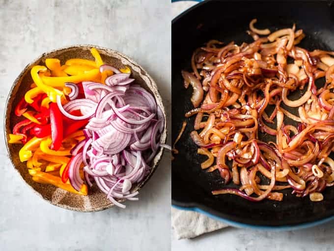 Sliced peppers and onions being sauteed in a cast iron skillet.