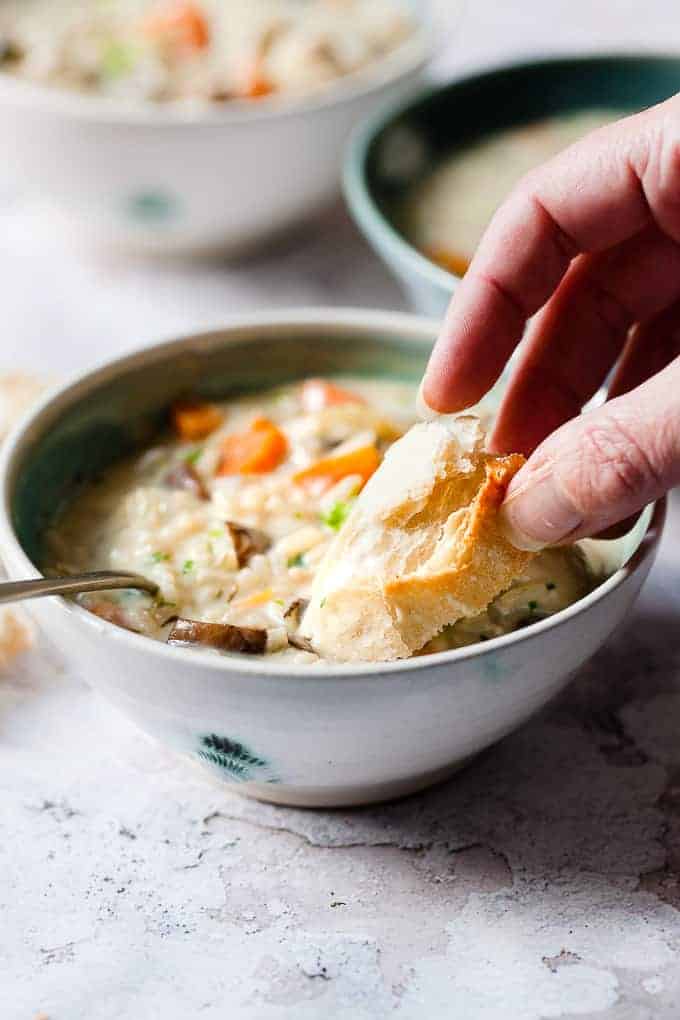 Chicken rice soup recipe in a bowl with bread.