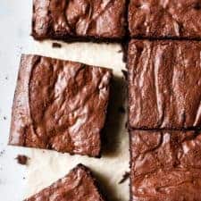 Easy brownies made with cocoa powder and dark chocolate on a white table.