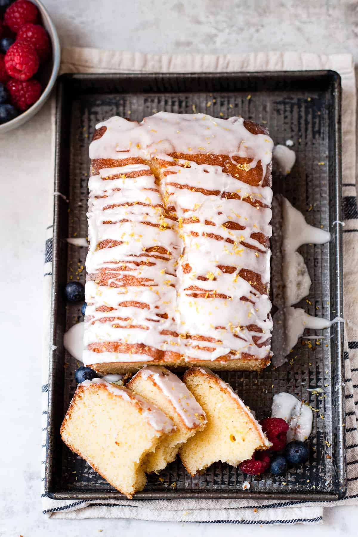 Lemon drizzle cake with berries and tender crumbs.