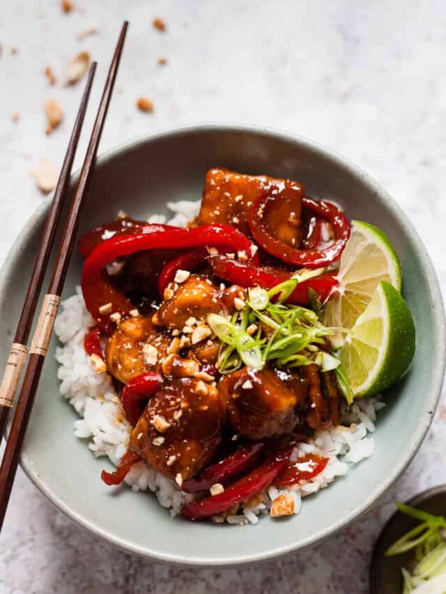 Sticky chicken with chop sticks and chopped peanuts.