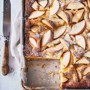 Easy apple cake in a baking tray on a marble table.