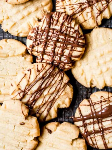 Mary Berry fork biscuits drizzled with chocolate on a baking tray.