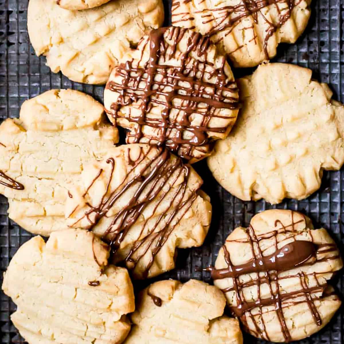 Mary Berry fork biscuits drizzled with chocolate on a baking tray.