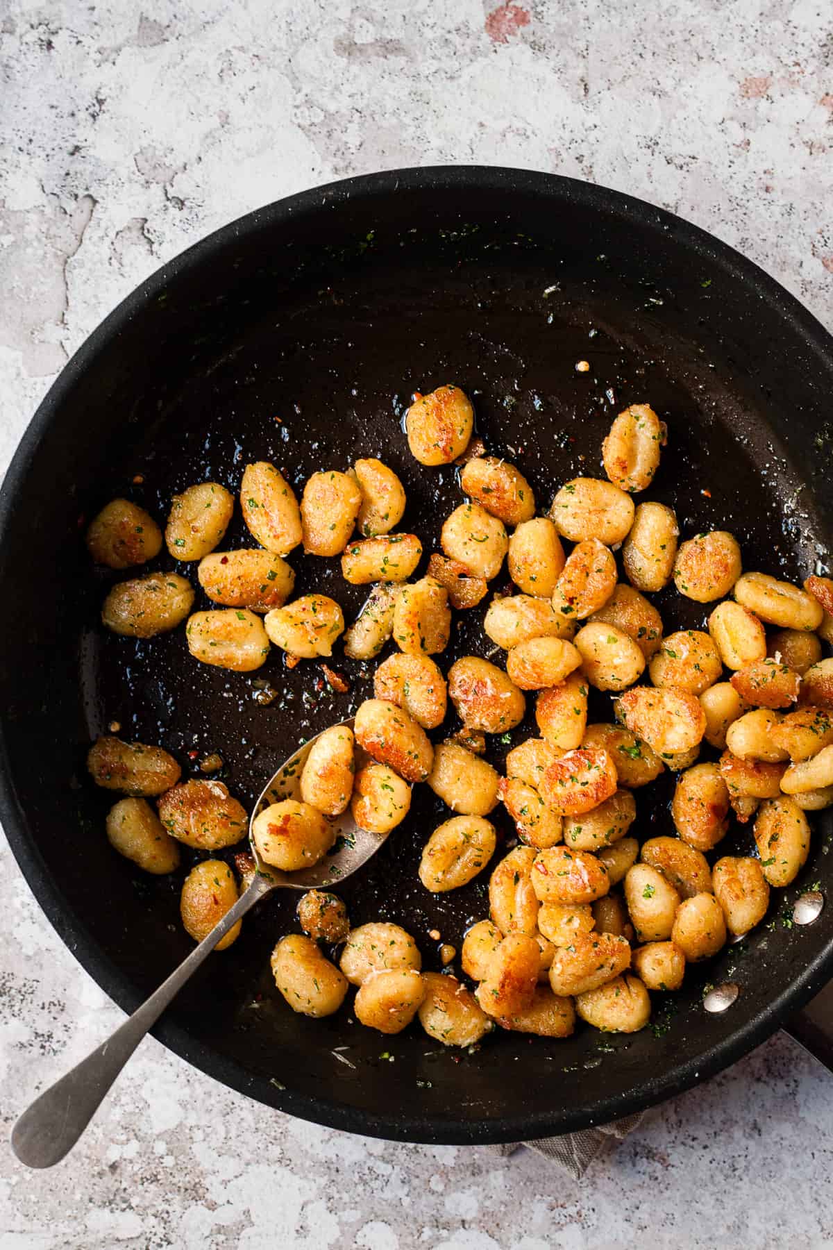 Crispy pan fried gnocchi in a pan.