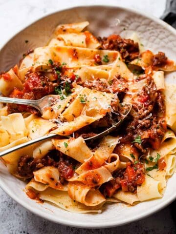 Close up bolognese in a white bowl.