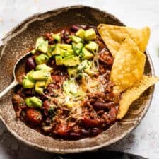 slow cooker chilli in a bowl with tortilla chips.