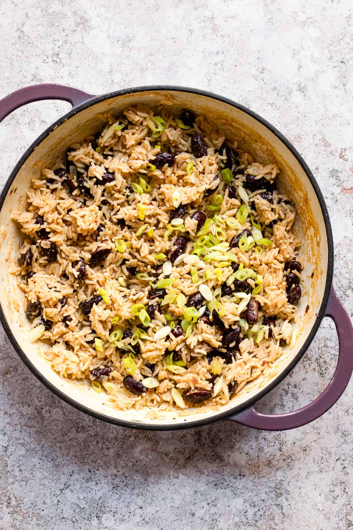 Rice and peas in a casserole dish on a white table. 