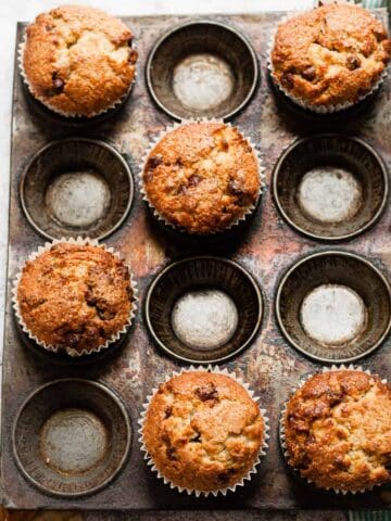 Muffins in a baking tin with a blue tea towel