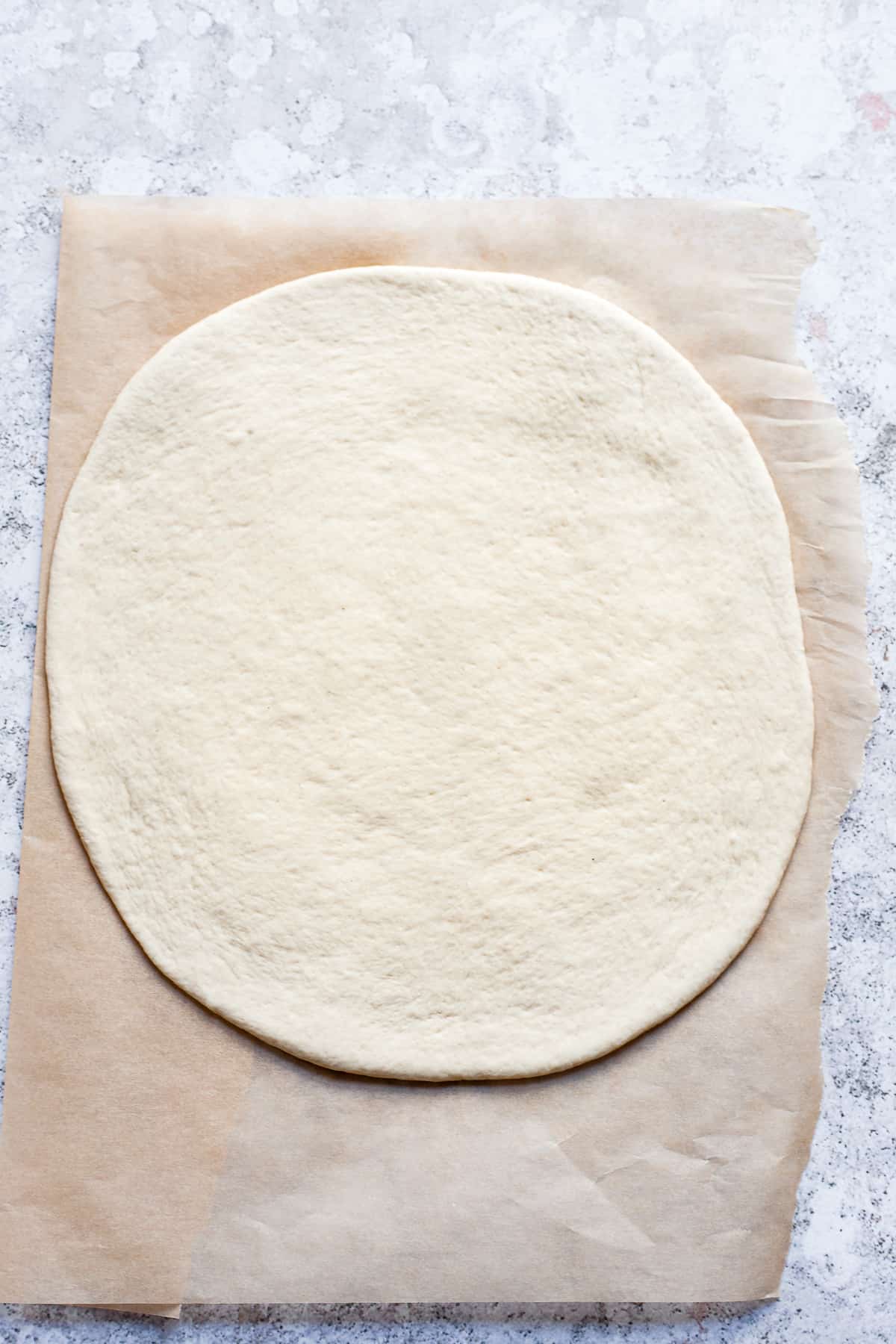 pizza dough rolled on a baking sheet.