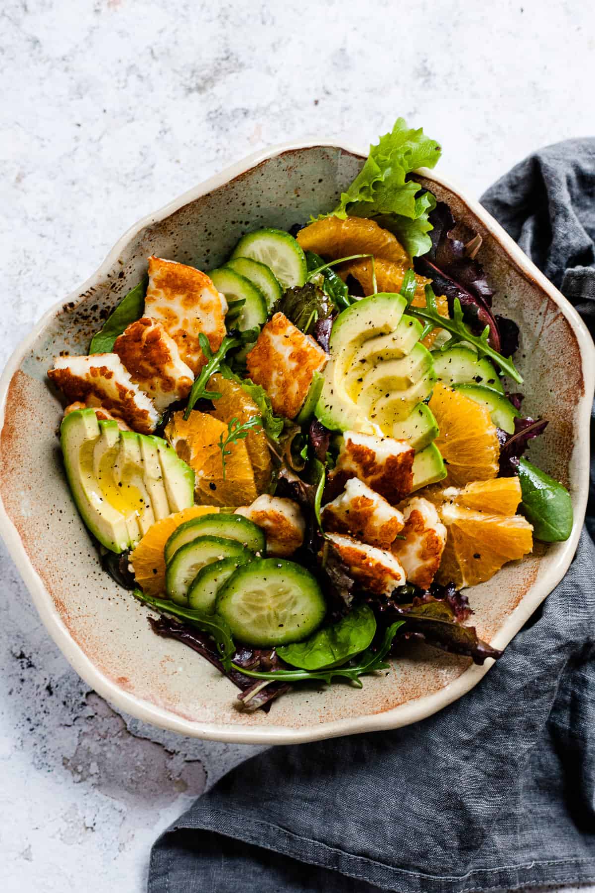 pan-fried halloumi salad in a bowl on a white table.