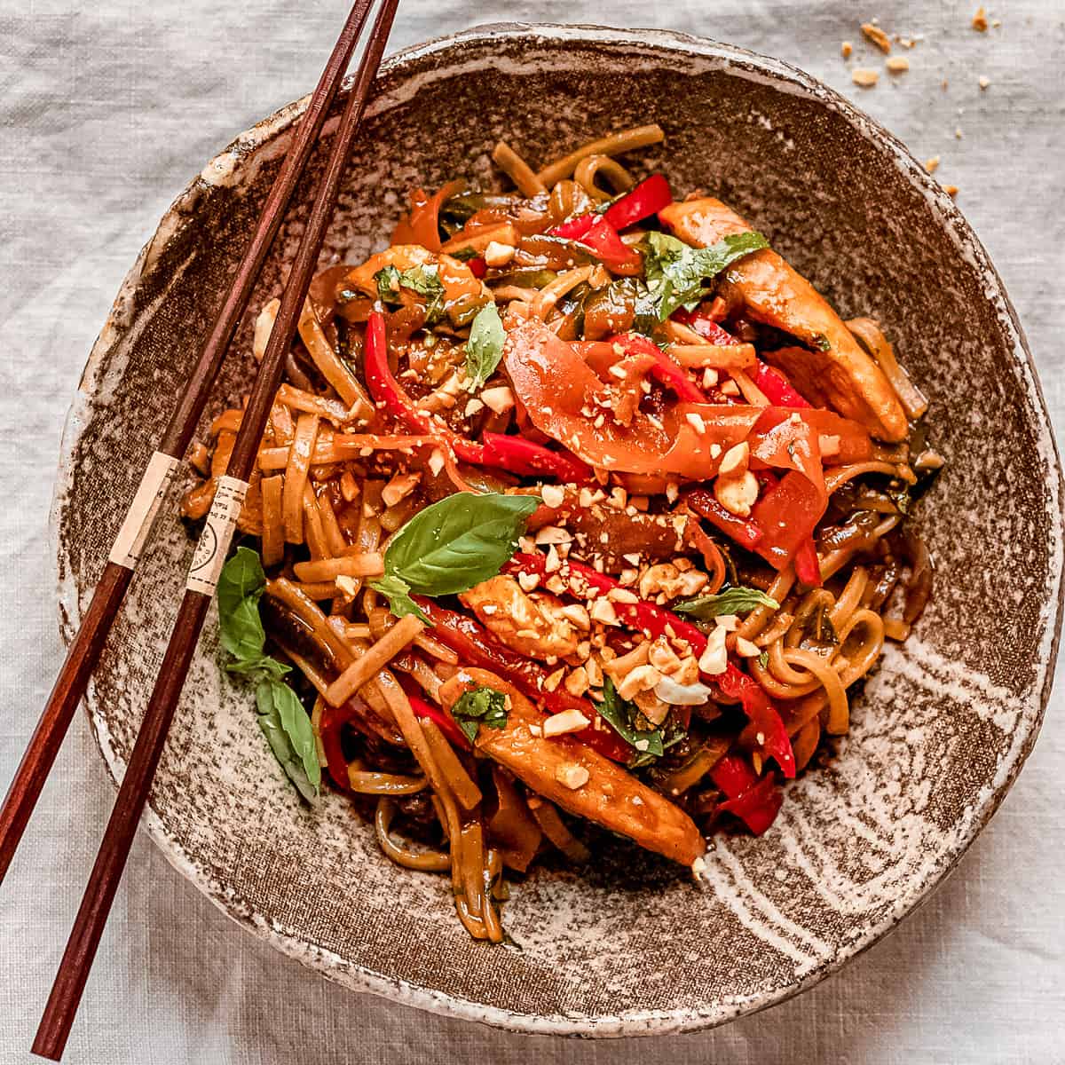 Asian chicken noodles in a brown bowl.