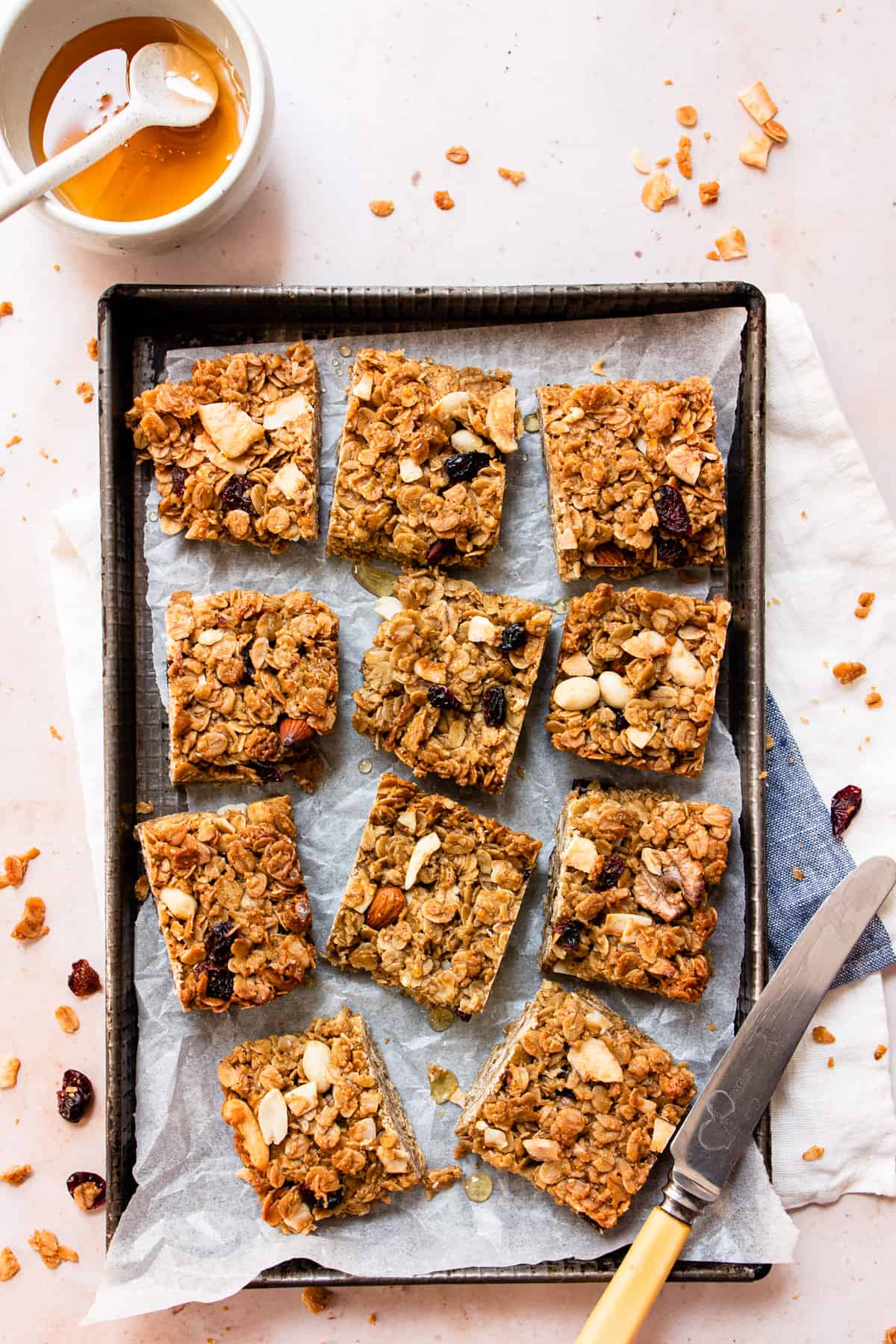 Healthy flapjacks on a baking tray with honey and nuts.
