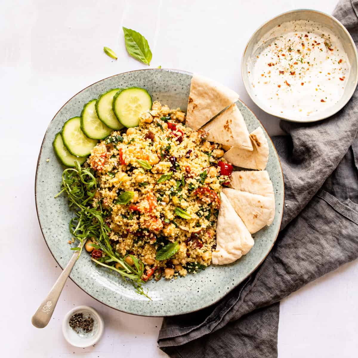 Moroccan couscous in a blue bowl with pita bread