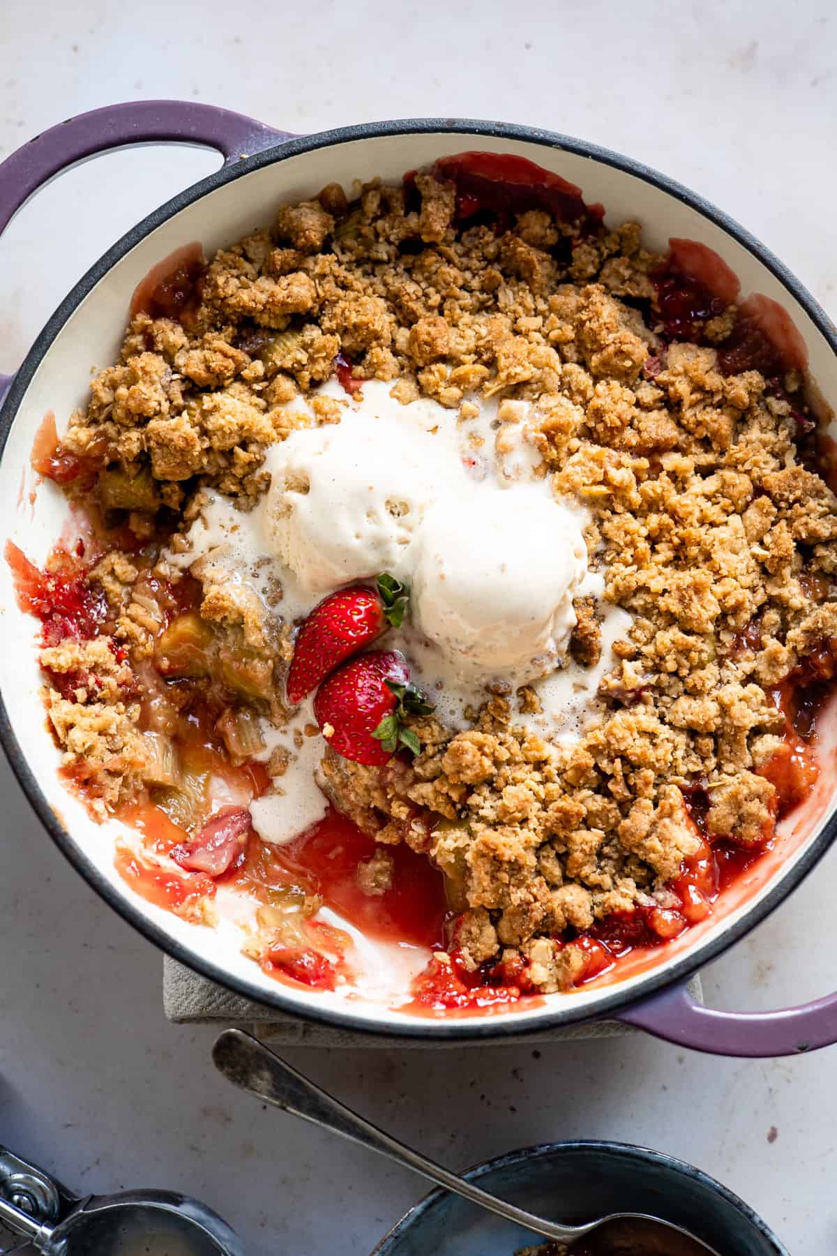 Rhubarb and strawberry crumble with oat topping and ice cream.