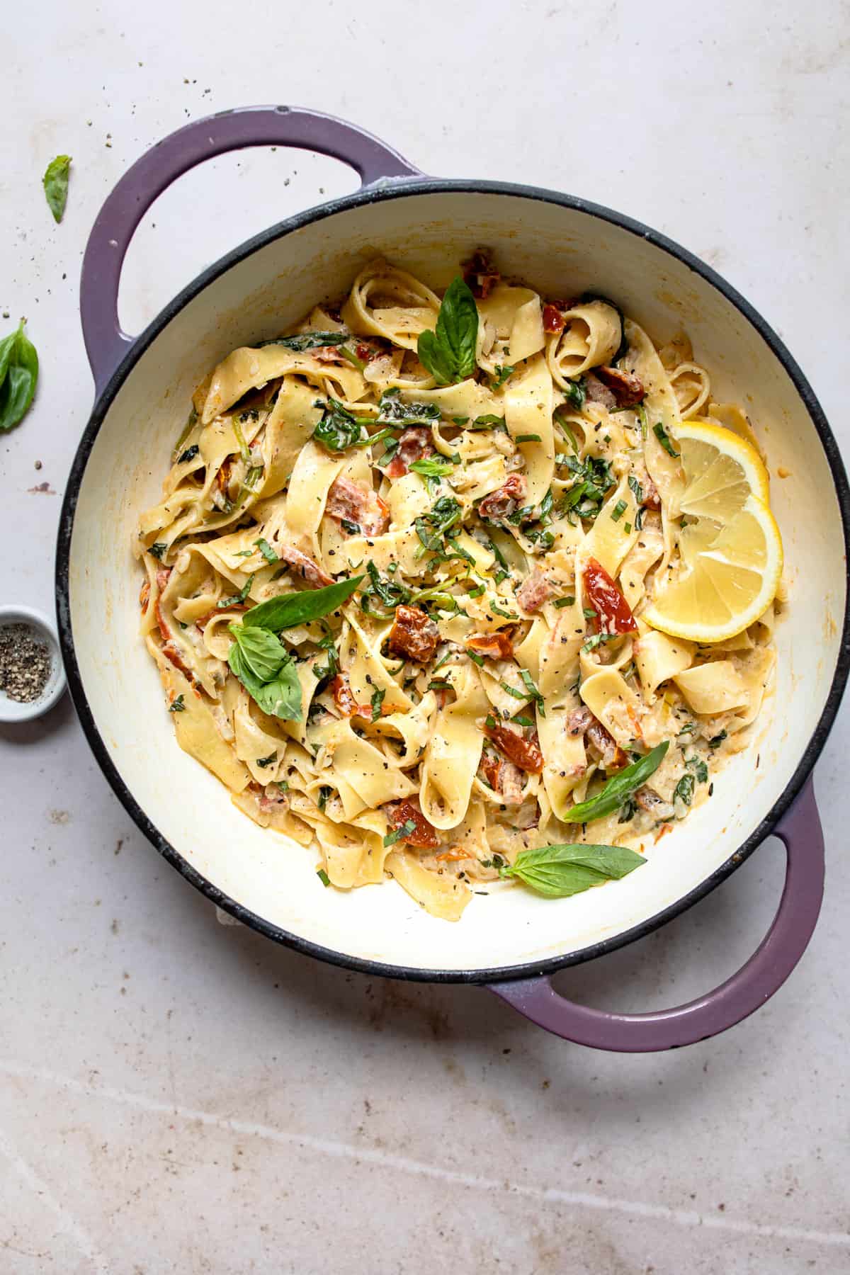 Creamy sundried tomato pasta in a pan with lemons and basil- healthy aldi recipes