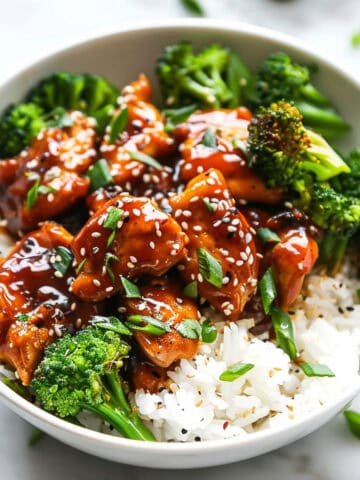 Korean chicken with spicy sauce in a bowl with broccoli and rice.