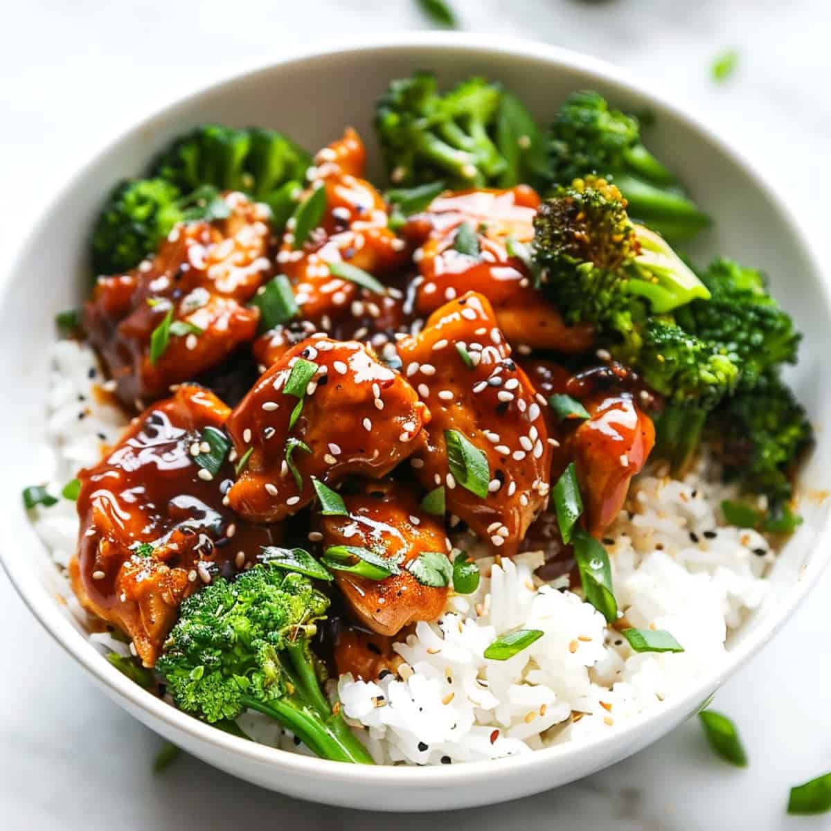 Korean chicken with spicy sauce in a bowl with broccoli and rice.