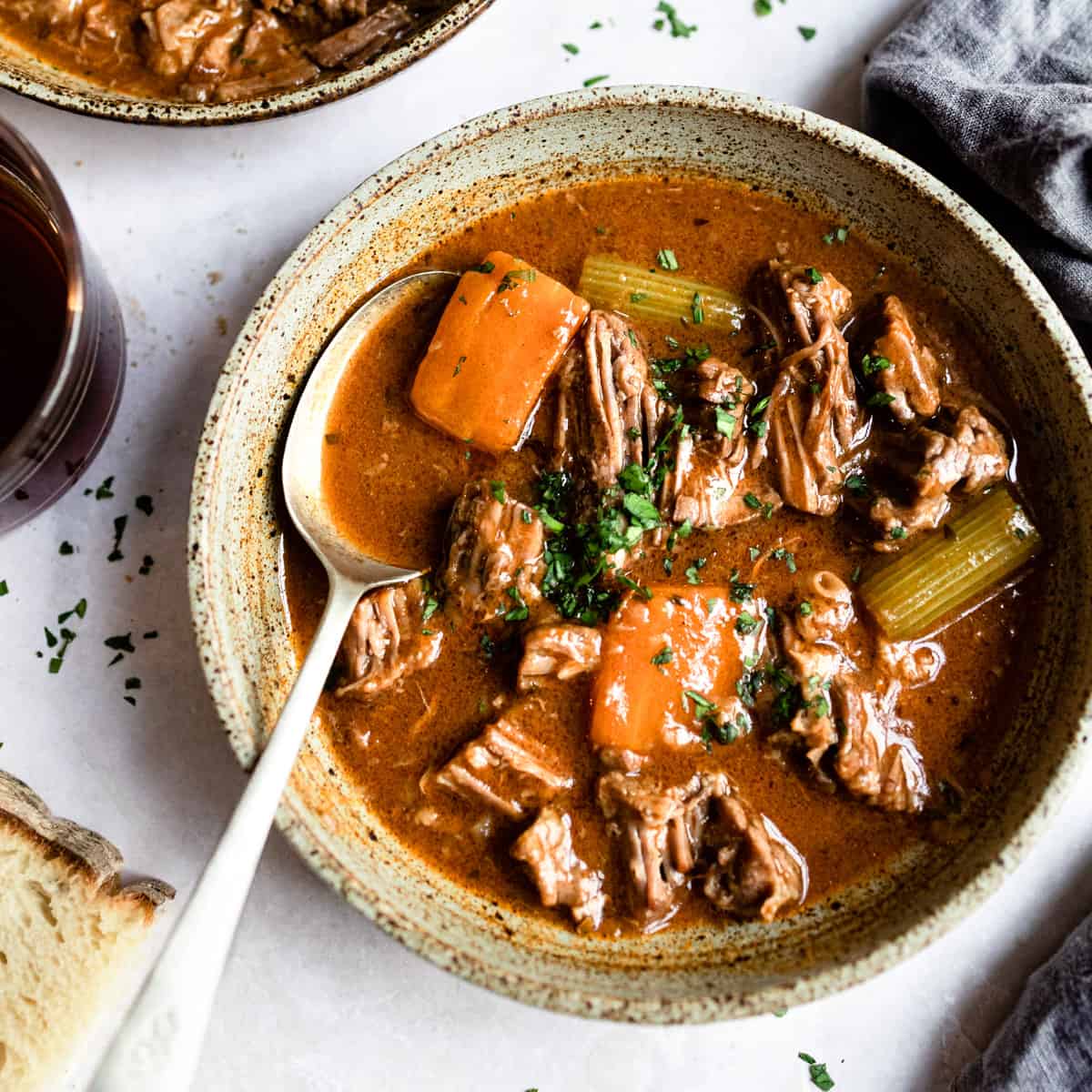 Beef and ale stew in a bowl with a spoon.