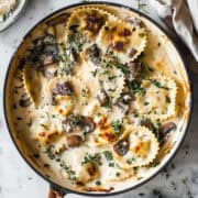 Creamy mushroom pasta bake with thyme in a skillet.