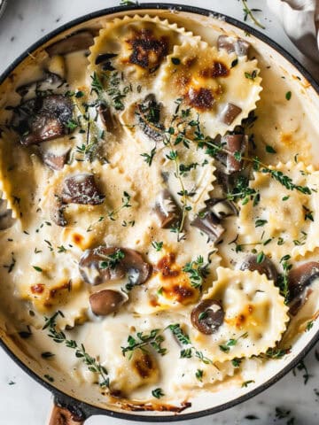 Creamy mushroom pasta bake with thyme in a skillet.