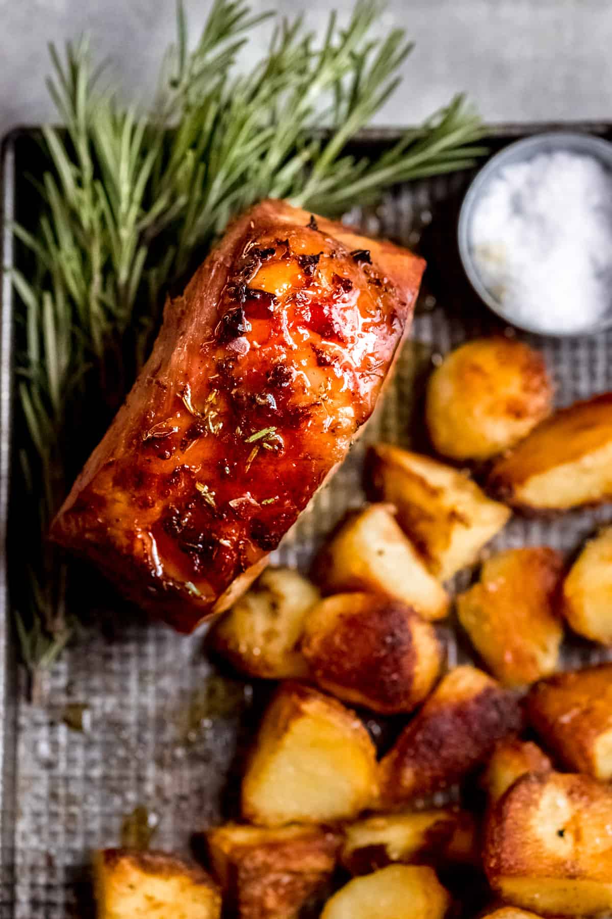 Gammon in cider on a baking tray with roast potatoes.