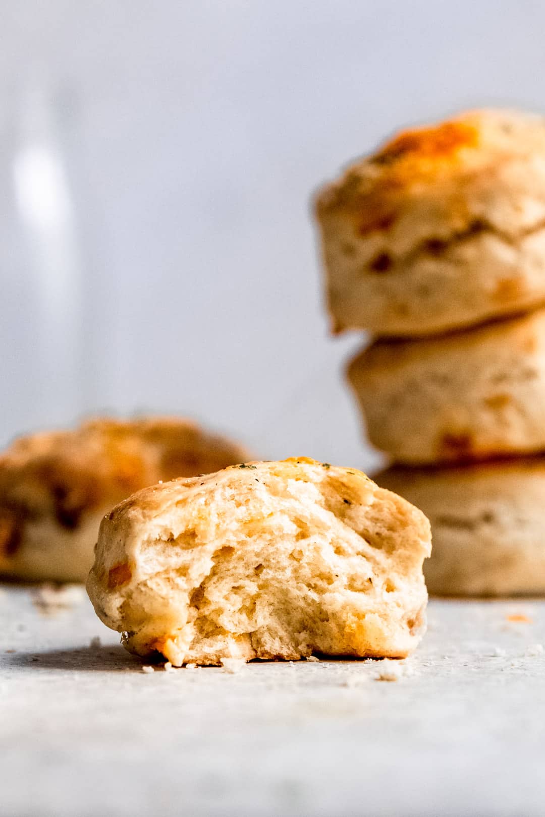 Cheese and bacon scone on a table with a bite taken out.