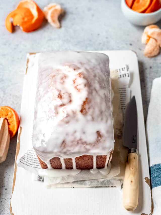 Orange drizzle cake on a cutting board.