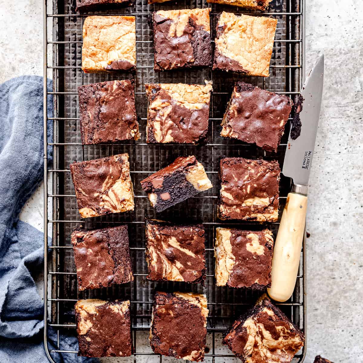 Baked brownie squares on a cooling rack.