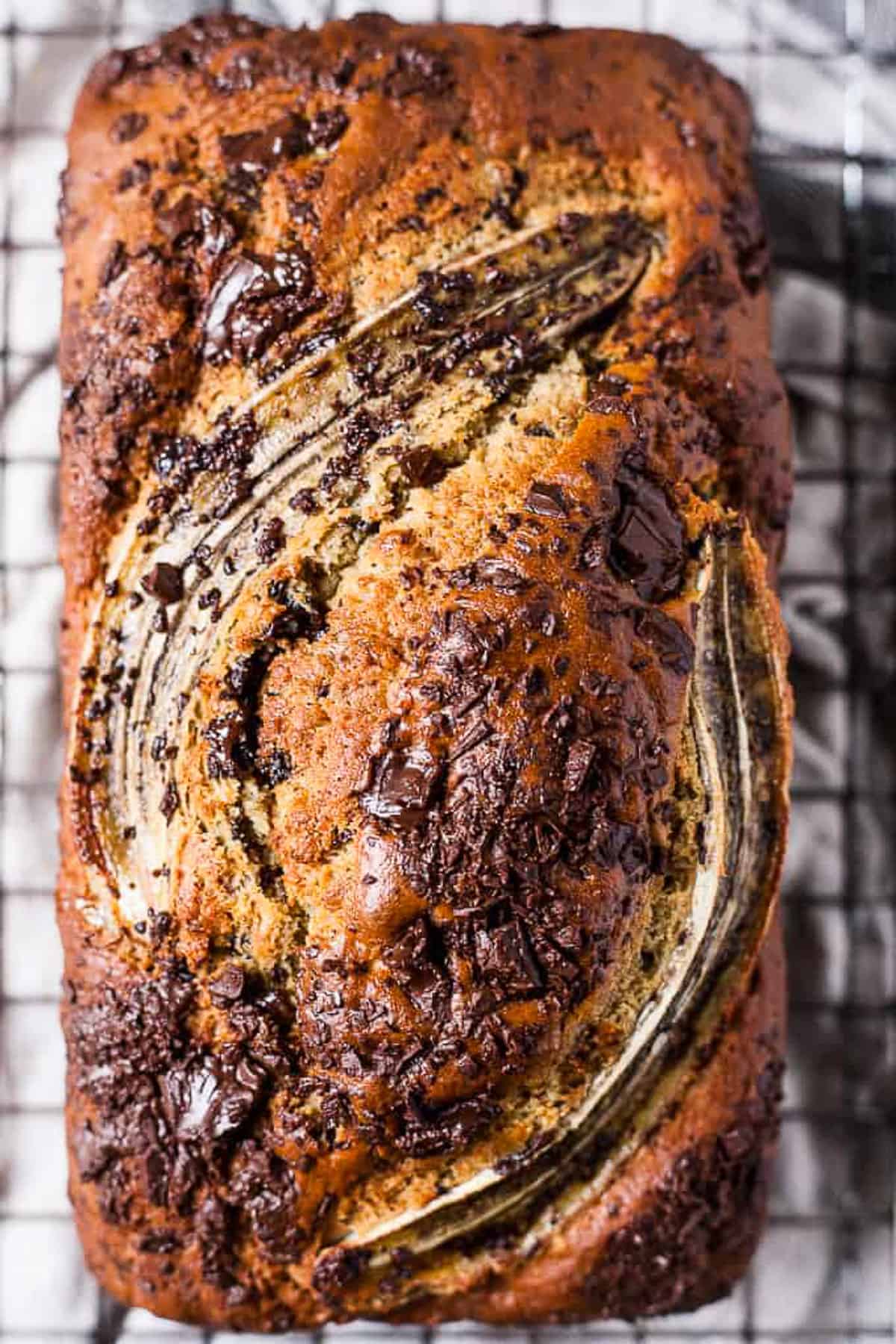 one bowl chocolate chip banana bread on a cooling rack.