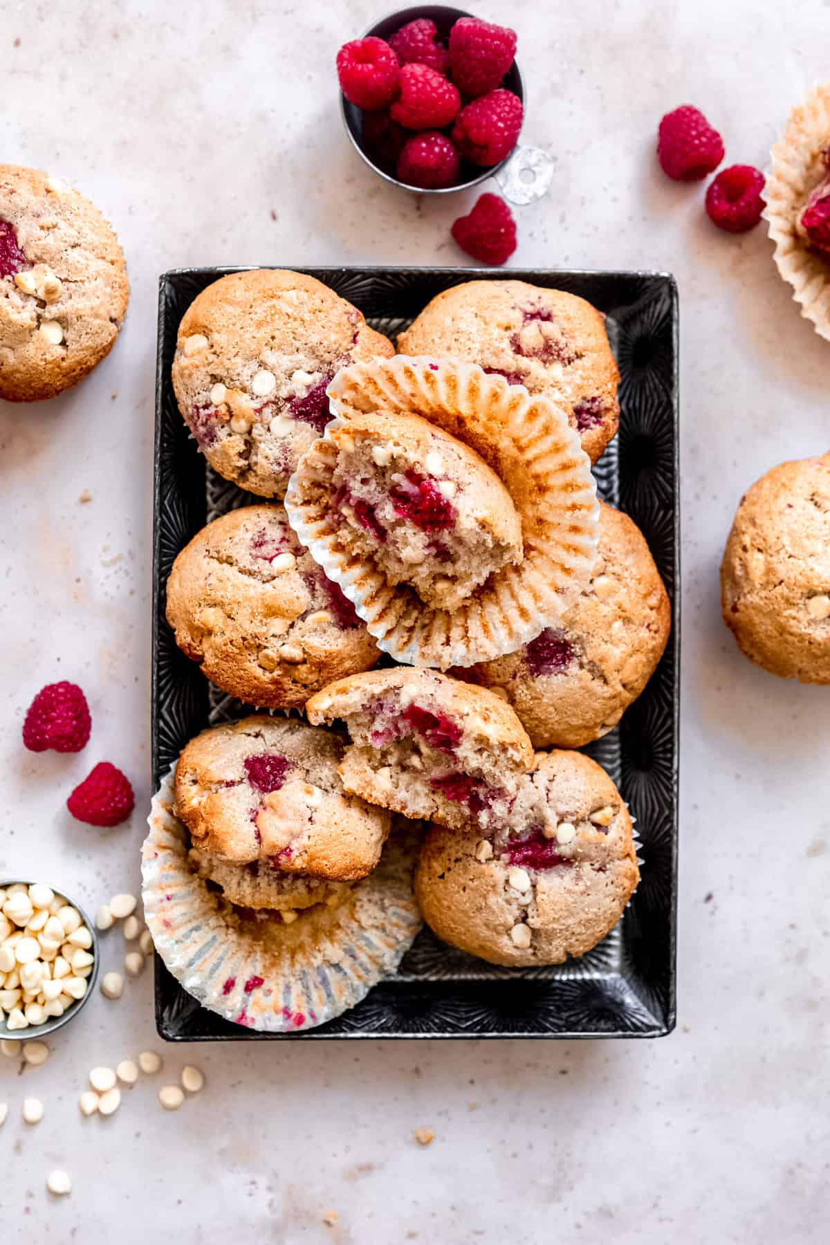 Raspberry white chocolate muffins in a baking tray.
