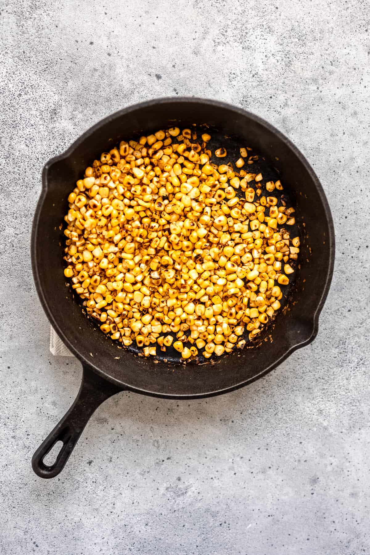Roasted corn in a cast-iron skillet.