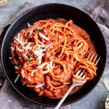 Rose pasta sauce with pasta in a black bowl.