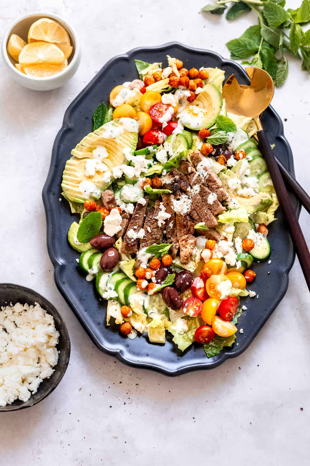 Greek gyro salad with feta and olives on a blue plate.