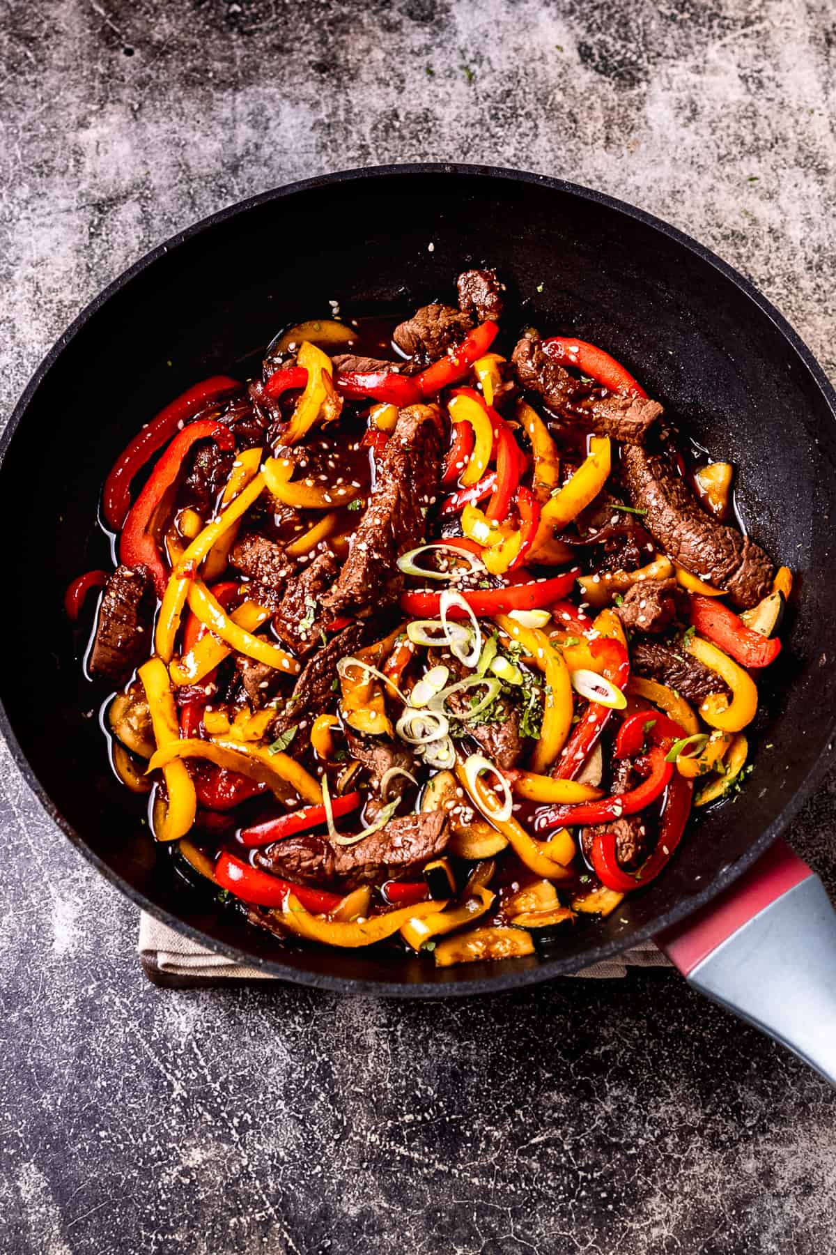 Beef stir fry with sauce in a wok.