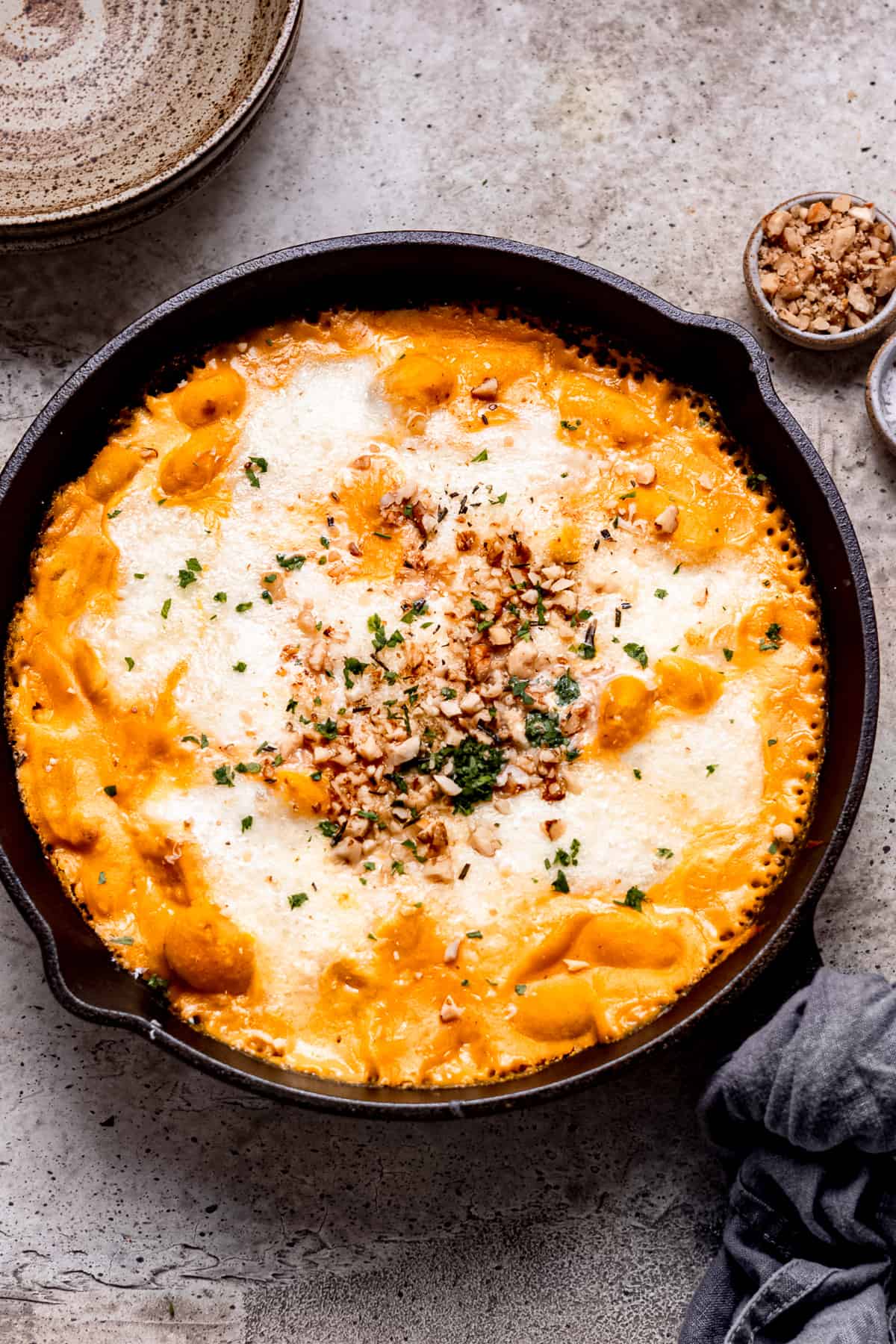 Butternut squash gnocchi baked in a skillet with cheese.