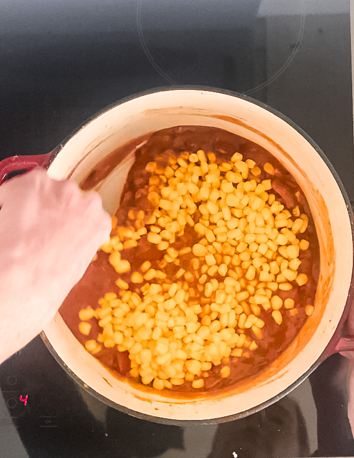 Sweet corn is added to a pot chili.