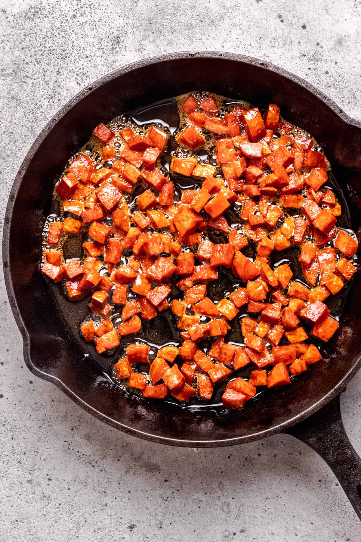 Chorizo being cooked in a pan.