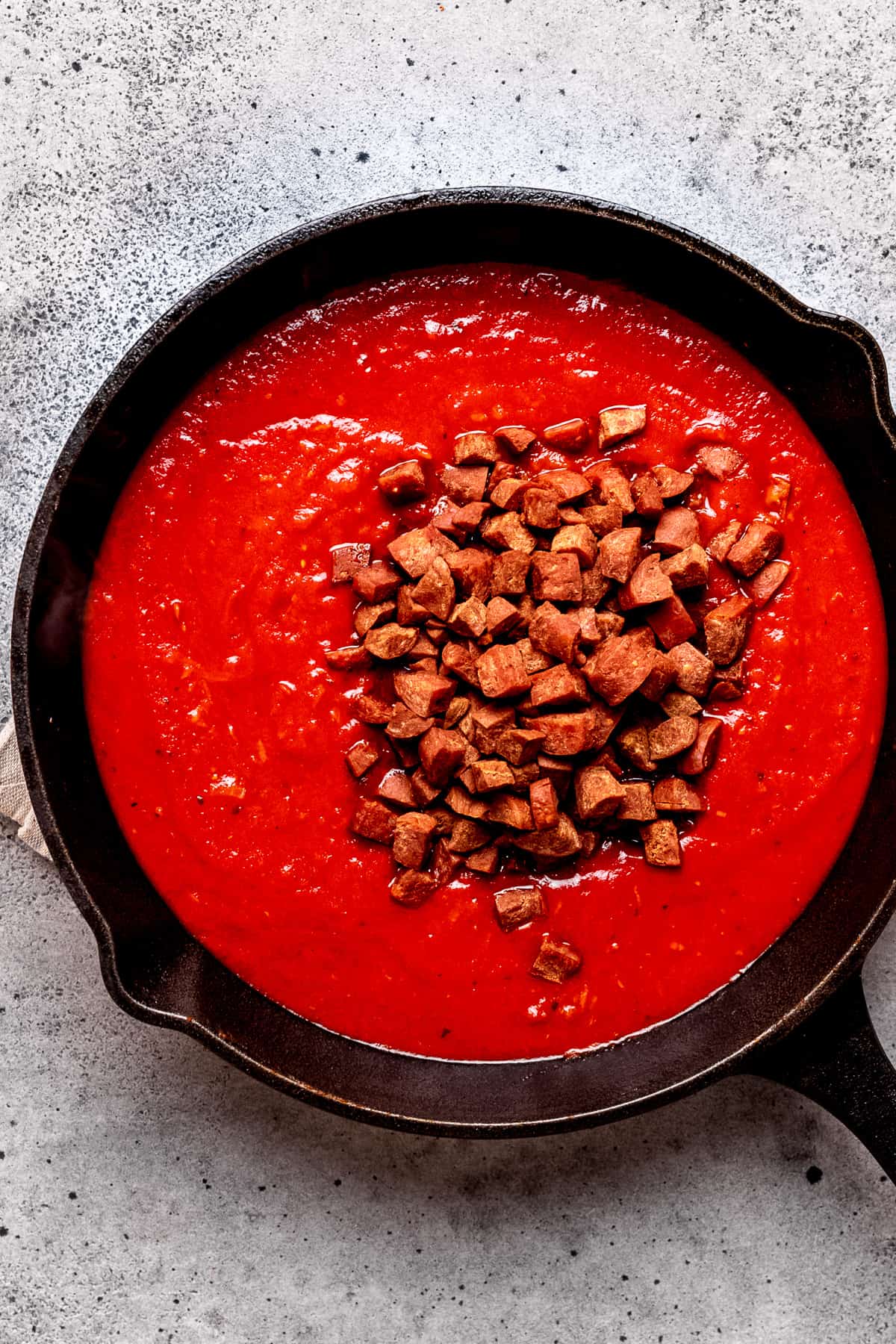 Tomato sauce with chorizo being added.