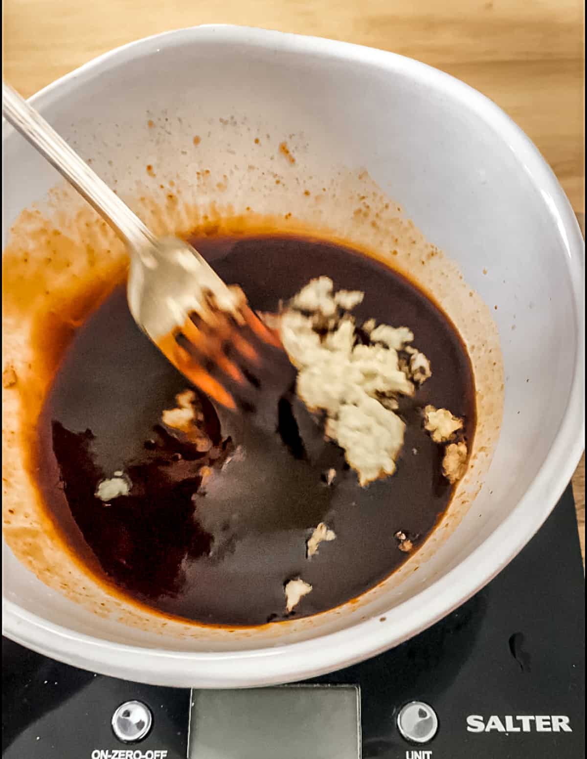 Ginger and garlic being whisked into sauce.