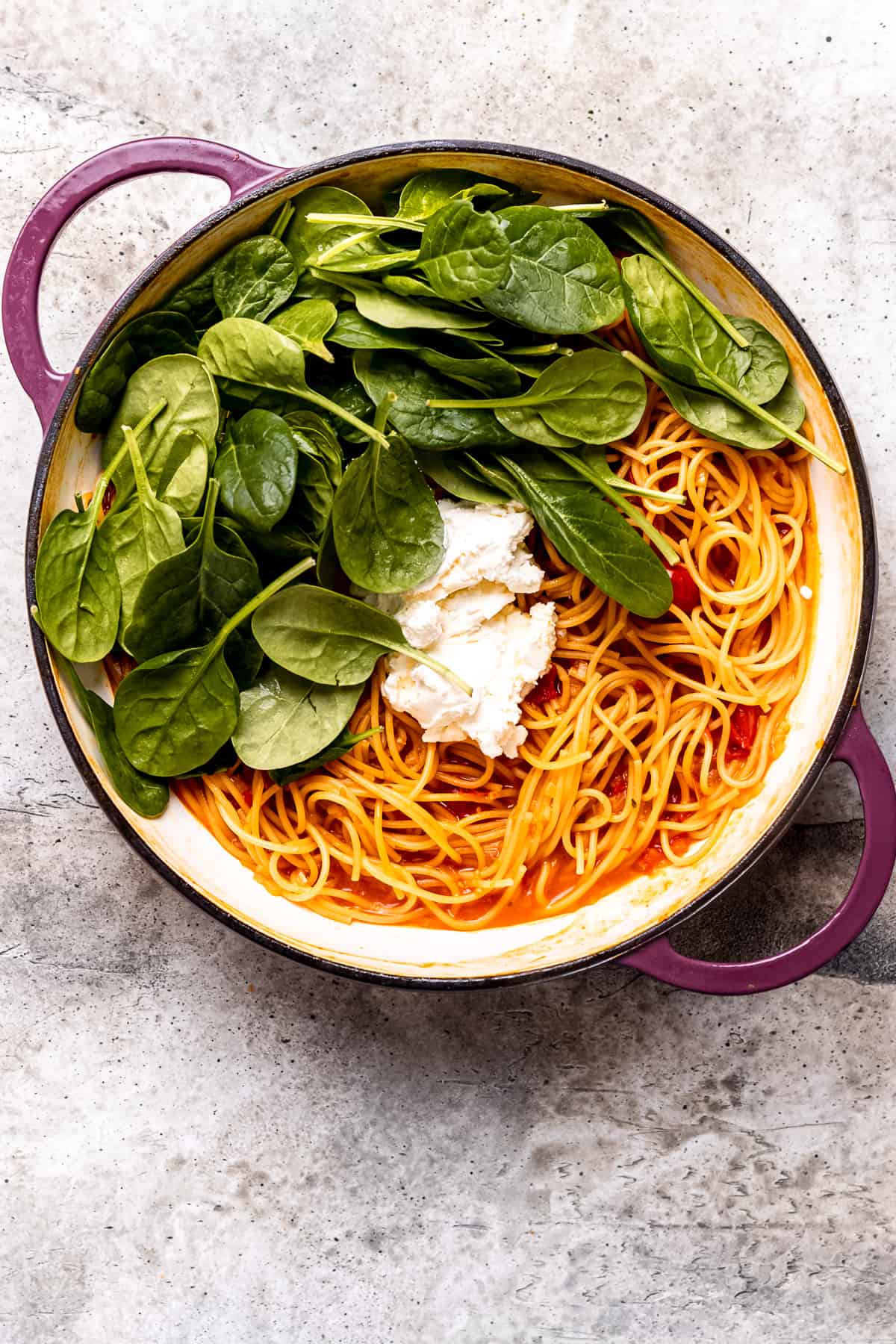 Spinach and mascarpone are added to a pan.