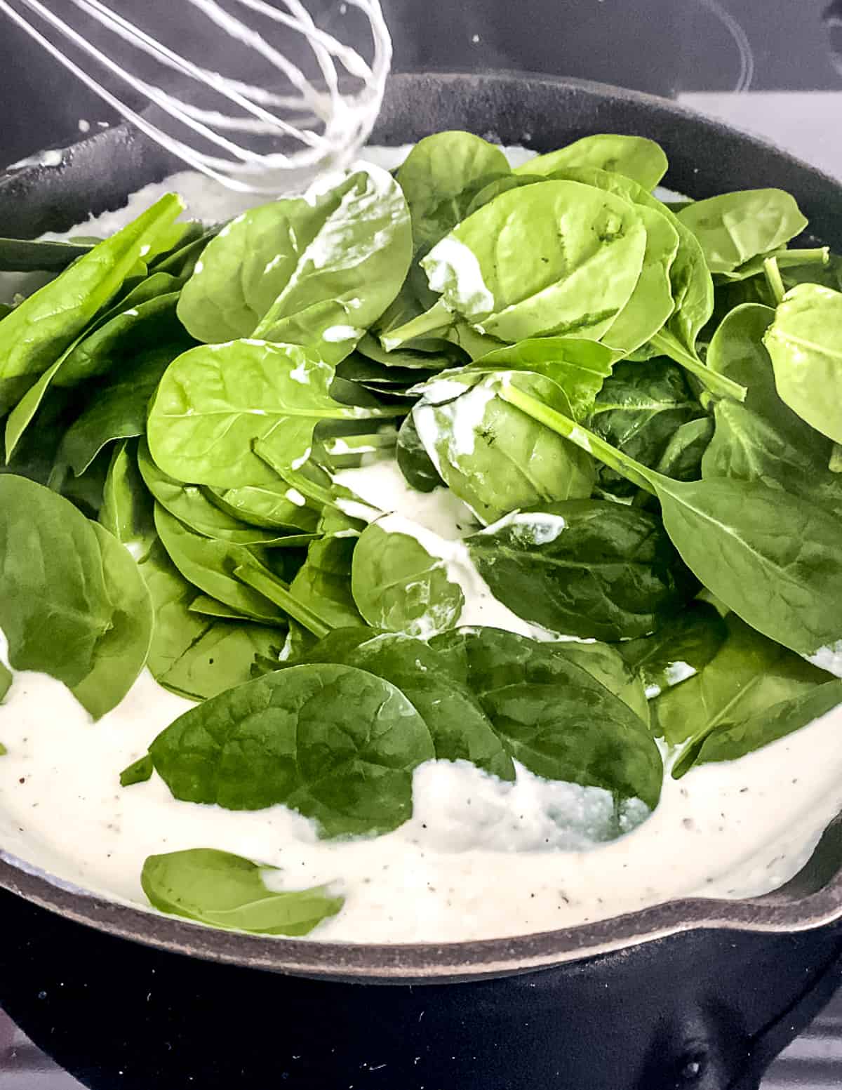 Spinach wilting in the ricotta sauce.