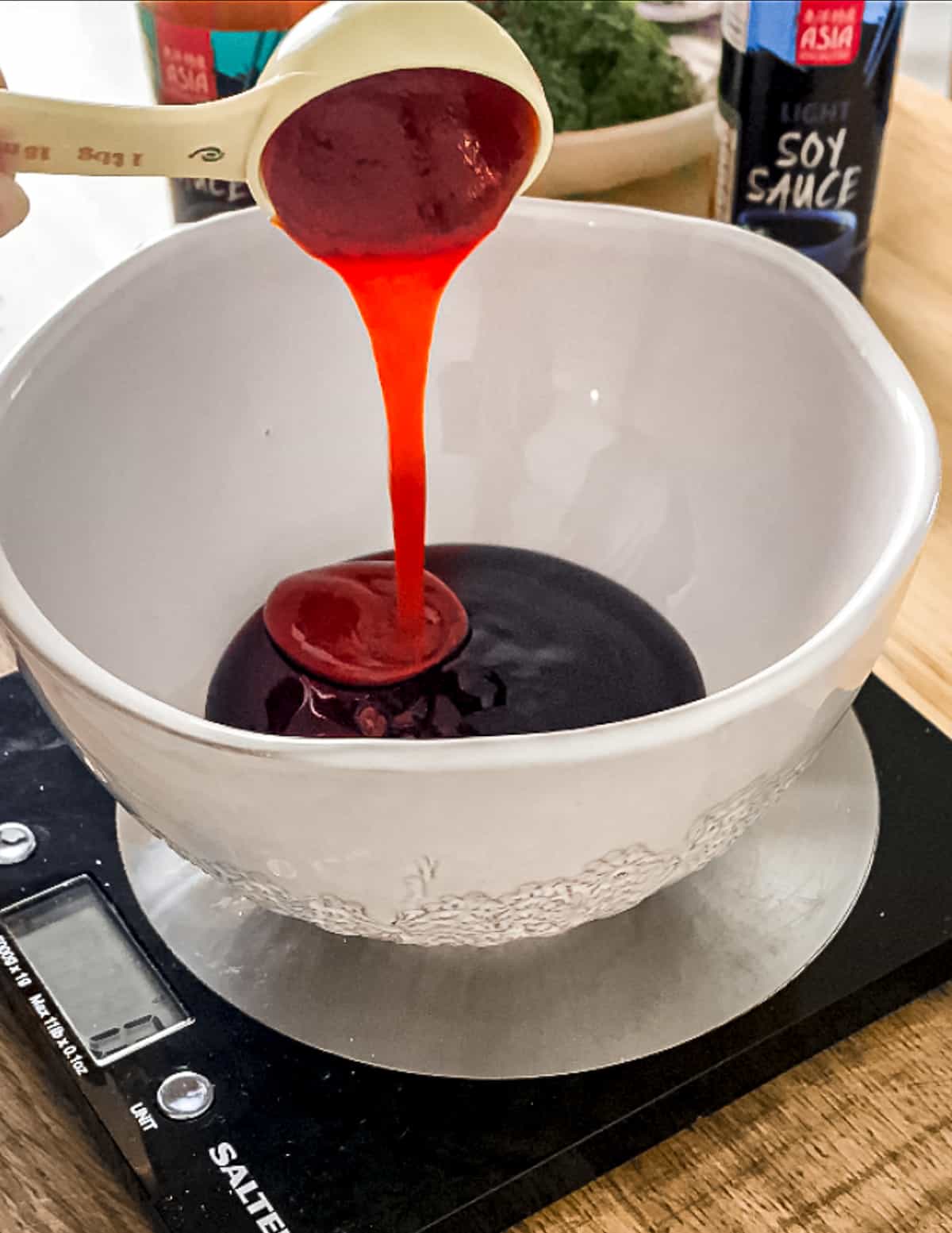 Sauce being added to a measuring cup.