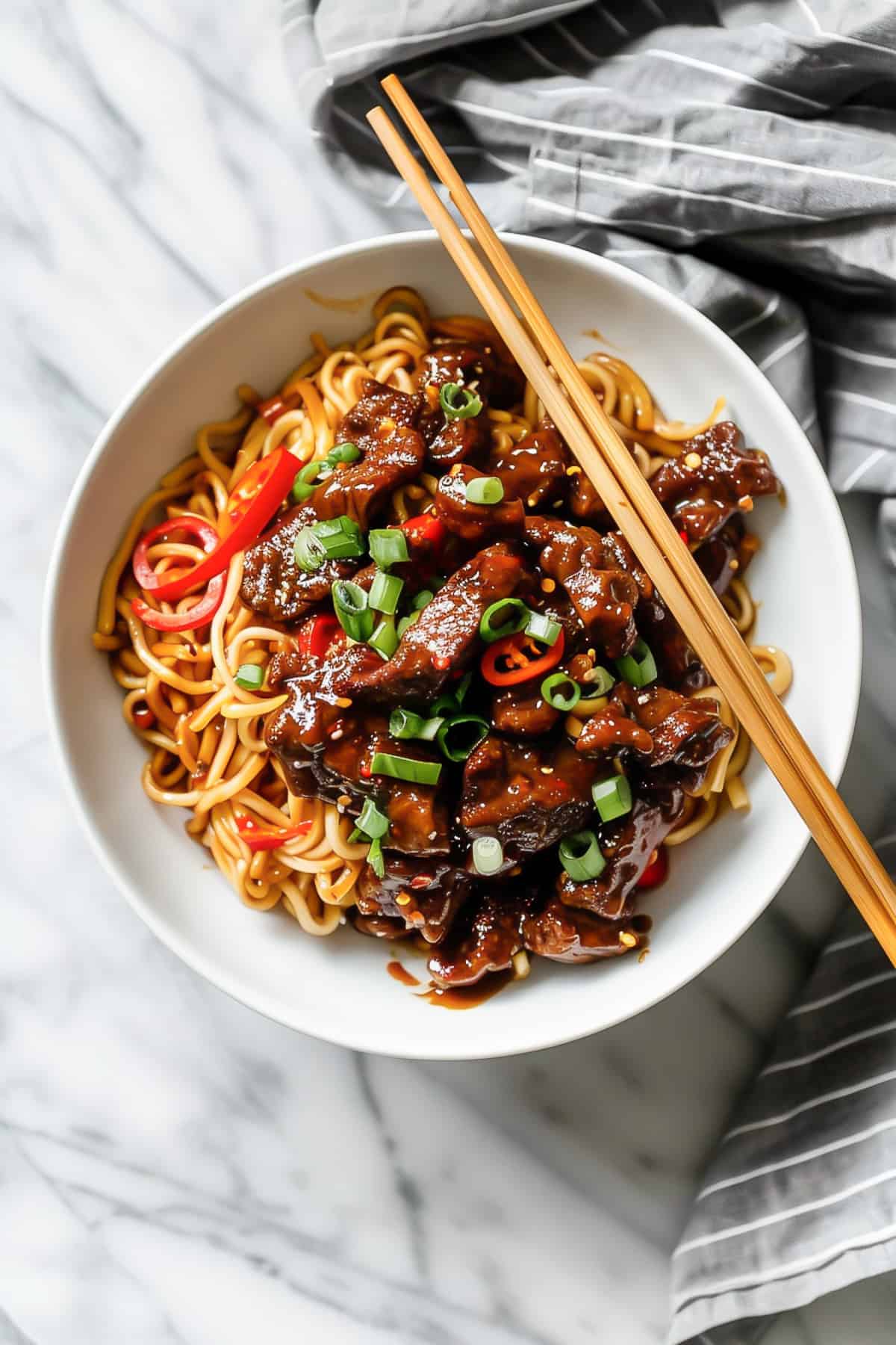 Crispy chili beef with Asian sauce and noodles.