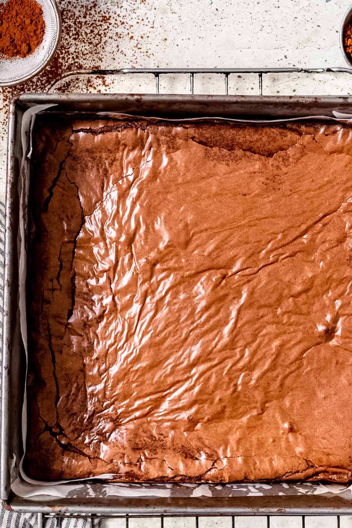 A tray of brownies with a shiny topping.