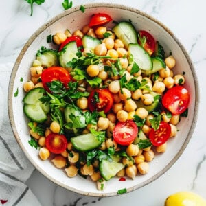 Easy chickpea salad with vegetables and vinaigrette in a white bowl.