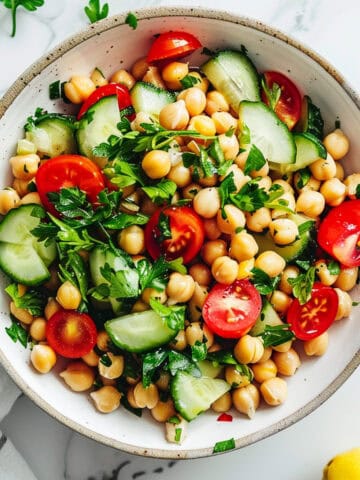 Easy chickpea salad with vegetables and vinaigrette in a white bowl.