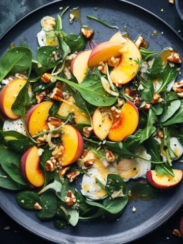 Peach and spinach salad on a blue plate.